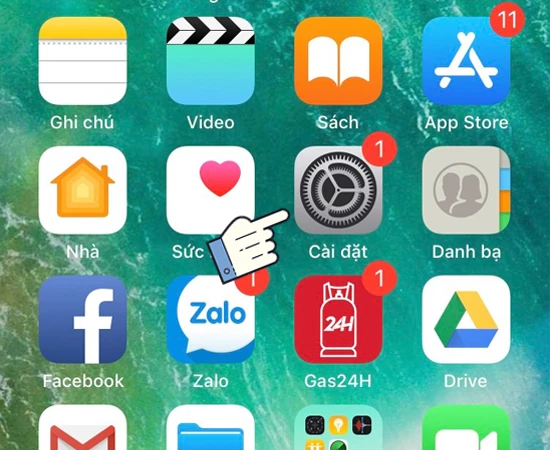 Màn hình điện thoại iPhone hiển thị ứng dụng, con trỏ tay chỉ vào Cài đặt, hướng dẫn chi tiết tại Kim Anh Mobile Đà Nẵng.