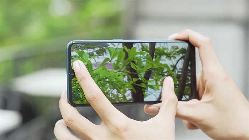 Người dùng đang trải nghiệm điện thoại thông minh, chụp ảnh phong cảnh tại Kim Anh Mobile Đà Nẵng.