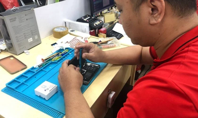Kỹ thuật viên Kim Anh Mobile đang sửa chữa điện thoại uy tín tại Đà Nẵng.